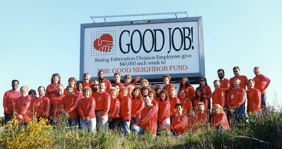 Boeing employees under a billboard advertising contributions from the Boeing Employees Good Neighbor Fund in 1989. 