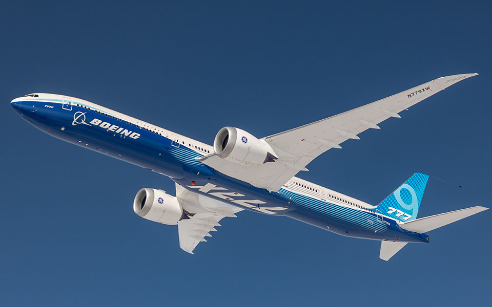 777X seen from the both up flying in a clear blue sky.