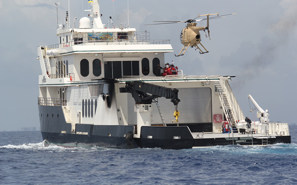 Picture of Unmanned Little Bird hovering over water craft.