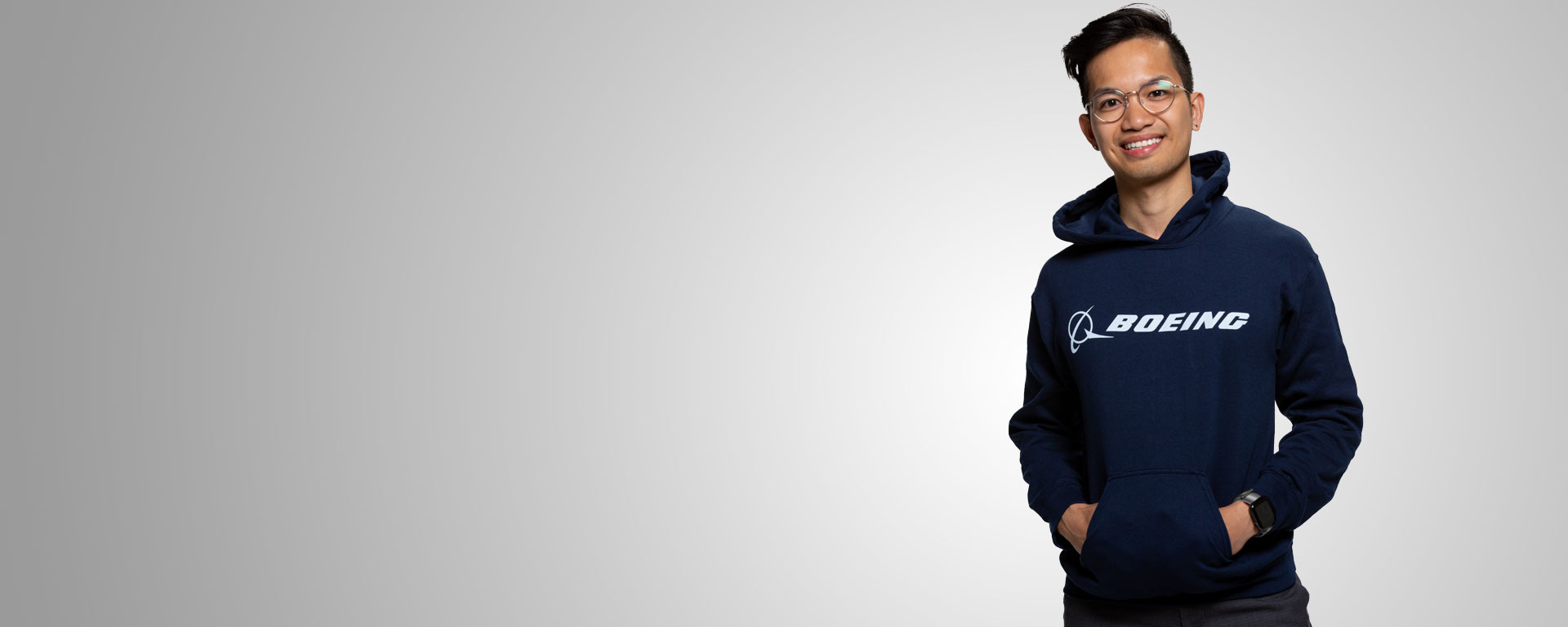 A person wearing a Boeing shirt crossing their arms