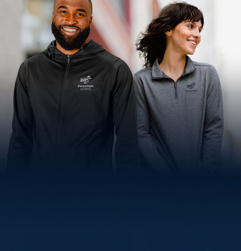 A man and a woman wearing A man and a woman standing next to each other wearing apparel pieces from the Phantom Works collectionpieces from the Phantom Works collection