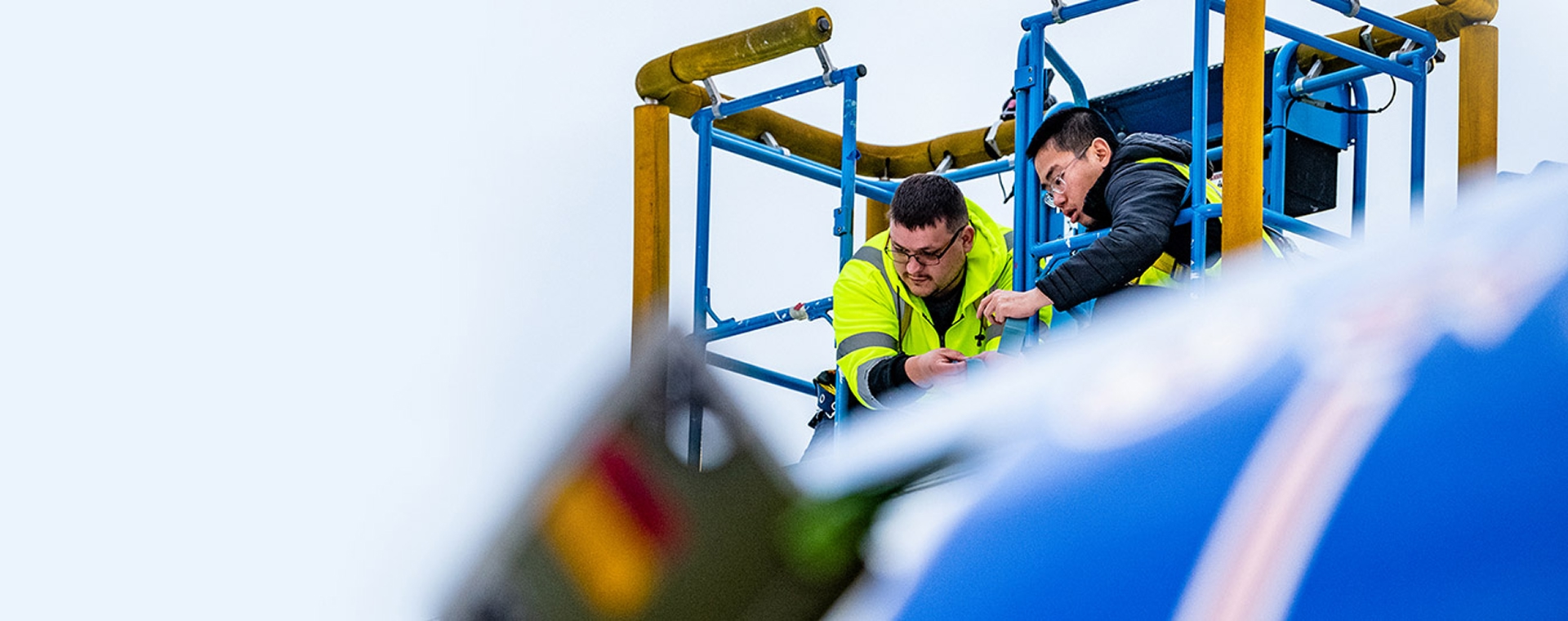 two people working on an aircraft from above the fuselage