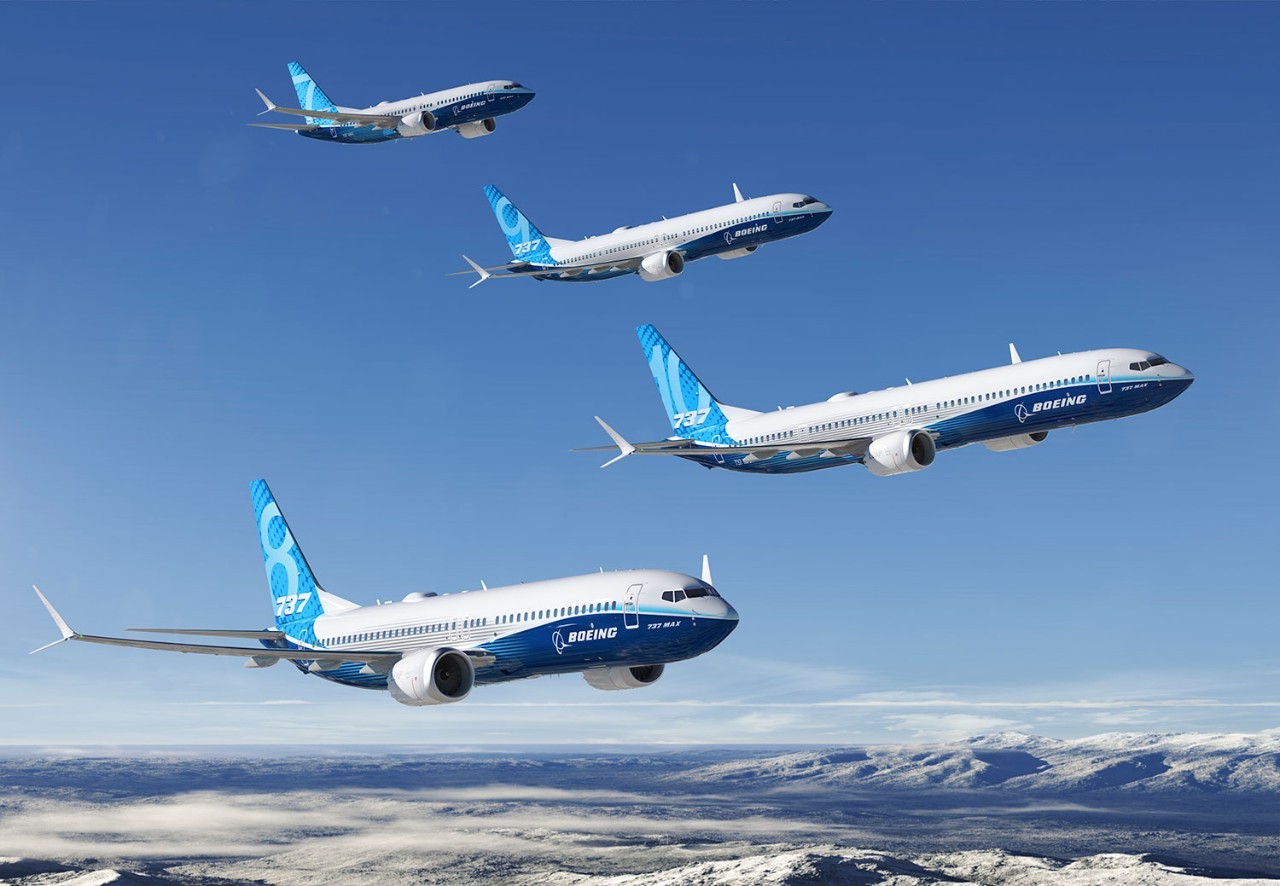 737 MAX Family in flightThe Boeing 737 MAX family of aircraft flying in formation against a clear blue sky and snowy mountains in the background.