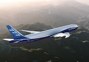 777 in flight over mountains.