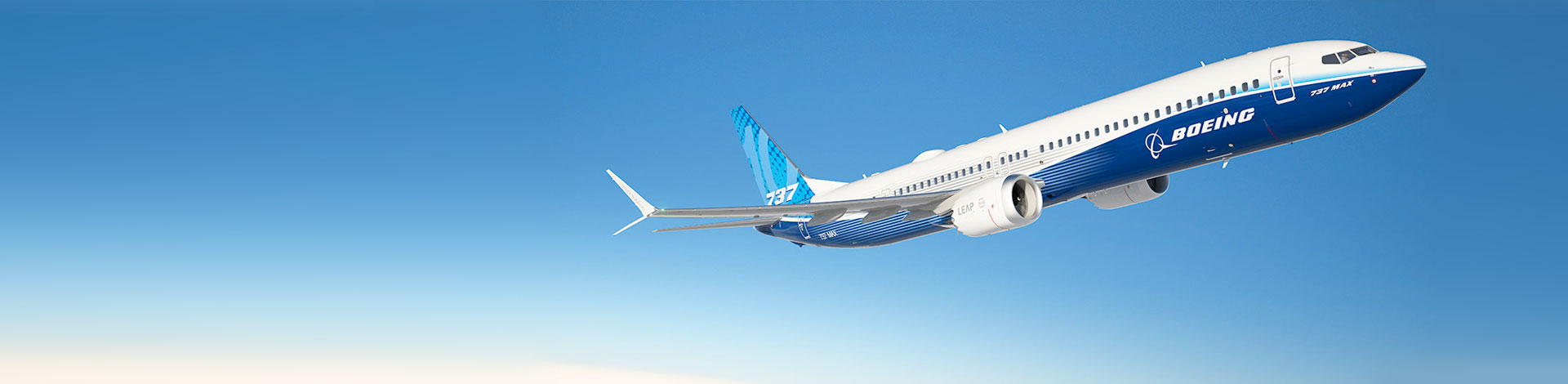 A Boeing 737 MAX flying high in the sky against a clear blue backdrop.