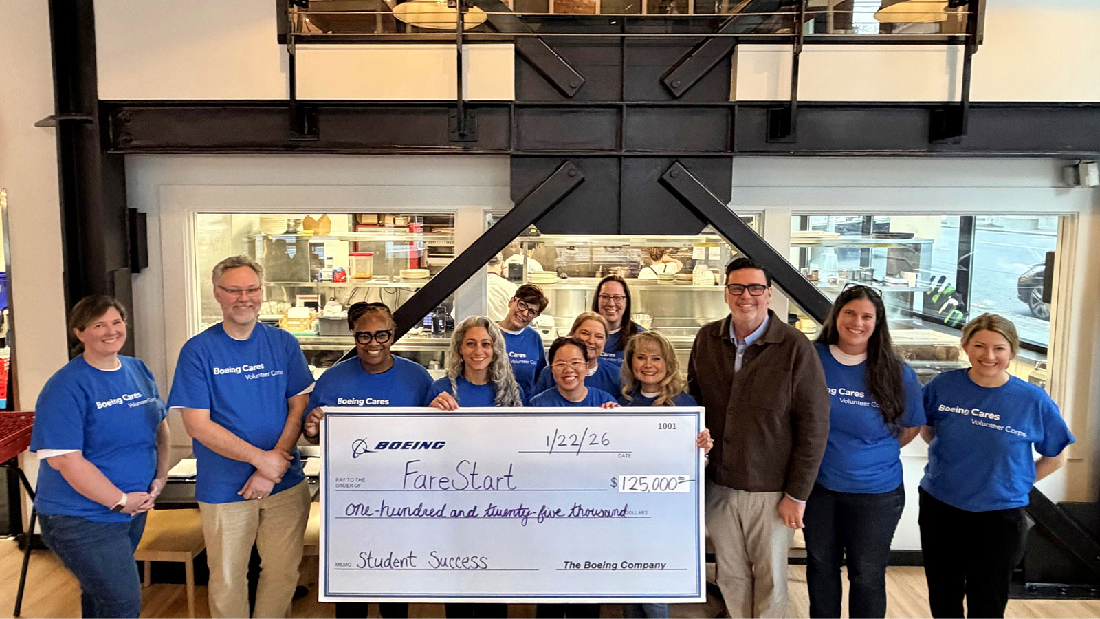 Boeing employees and FareStart team members celebrate their partnership with a $125,000 check in support of community growth and success.