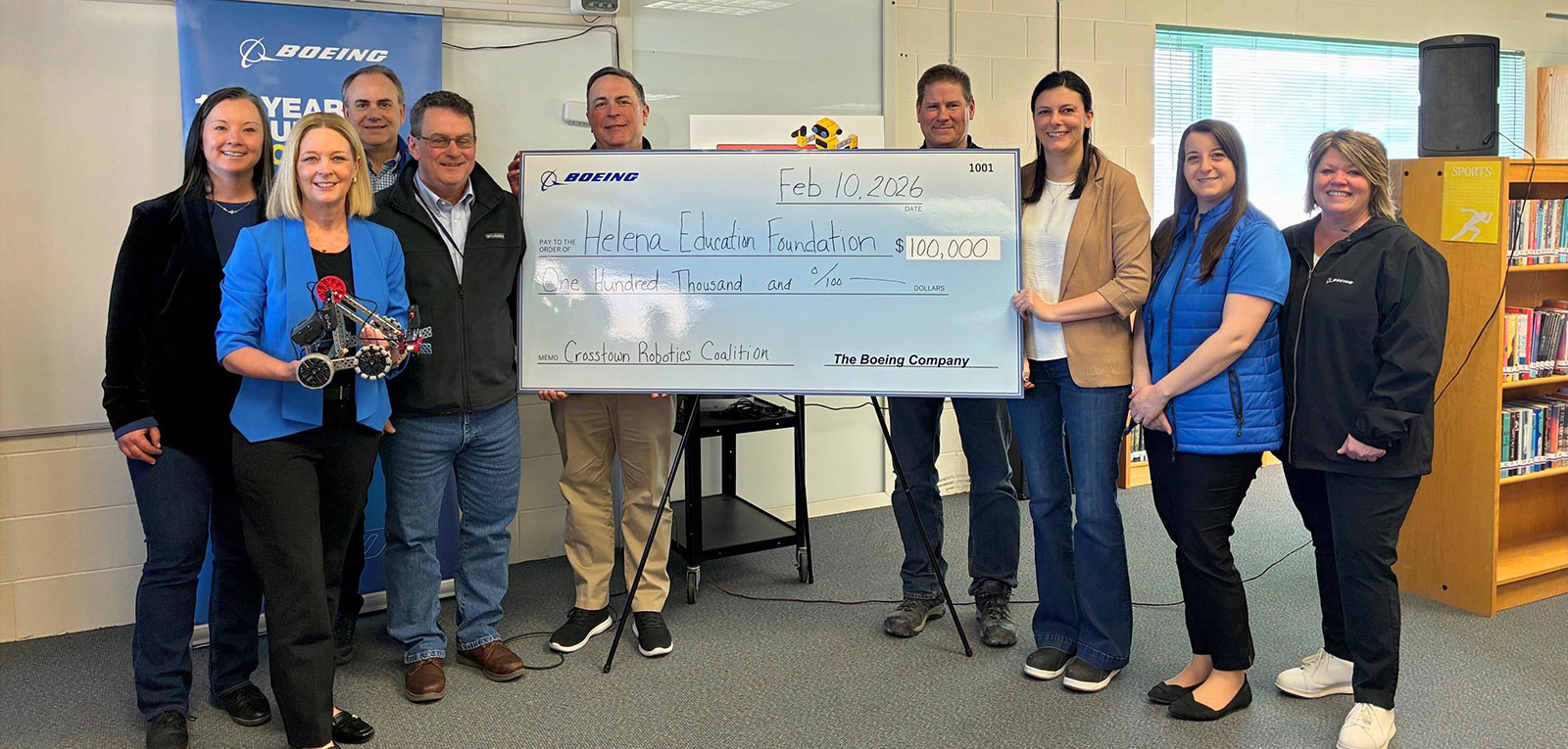 Boeing employees and Helena Education Foundation team members celebrate their partnership with a $100,000 check in support of new robotics initiative, enhancing STEM education and career pathways in Helena, Montana. Left to right: Amanda Northrup, Amy Frazier, Paul Witham, Kevin Poulin, Rich White, Dustin Nelson, Brittany Beach, Kelly Ostrem Trull, Lisa Blaise.