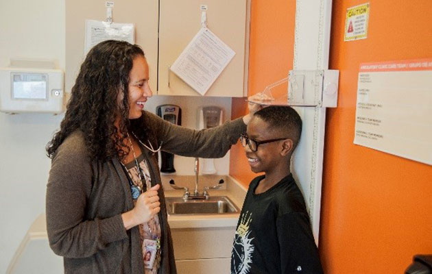 Woman measuring child's height.