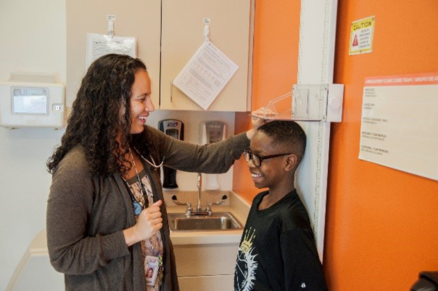 Woman measuring child's height.