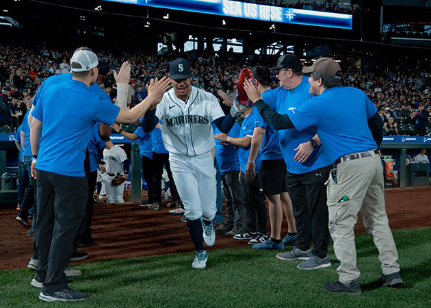 Members of the Puget Sound Chapter of the Boeing Veterans Engagement Team greet Seattle Mariners players as they take the field at Salute to Armed Forces Night presented by Boeing