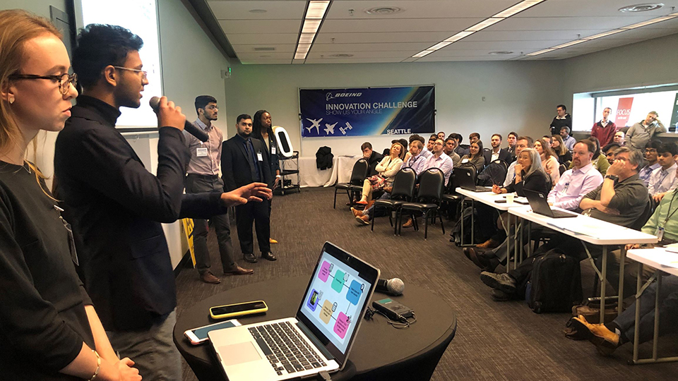 Students presenting to large group.