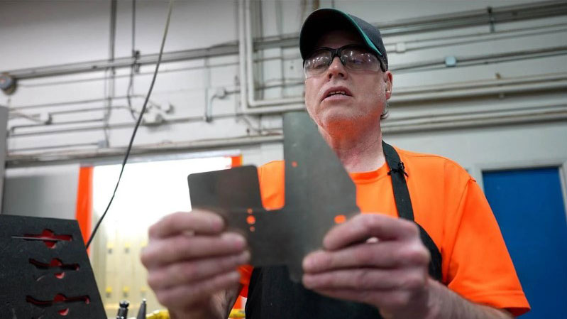 Michael King, a CNC machinist for Boeing supplier Lighthouse for the Blind, Inc., shows off a part he made that will go on a Boeing plane. King, who has Retinitis Pigmentosa, completely lost his vision in his 40s.
