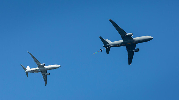 The KC-46A makes its way across the sky with the P-8A trailing behind it. 