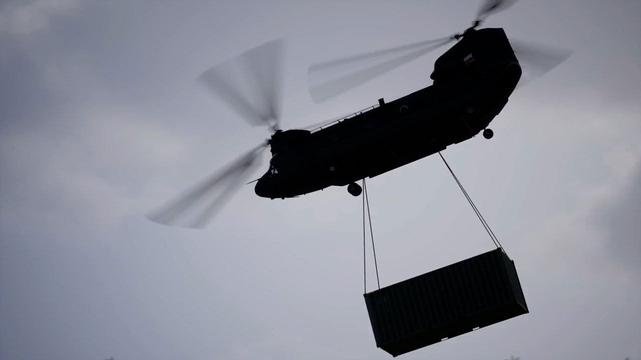 Animation of a CH-47F Block II Chinook helicopter in flight carrying a cargo container.