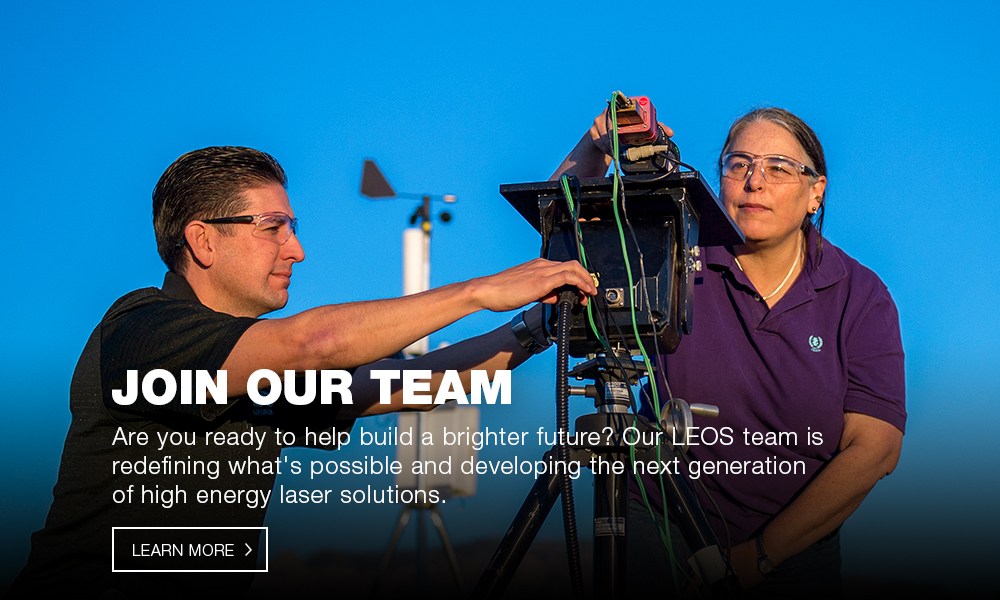 Joi our team image featuring two workers adjusting a laser & electrical-optical system (LEOS)