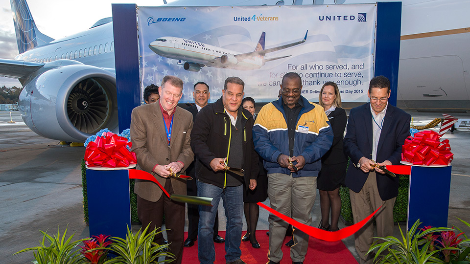 Representatives of Boeing and United Airlines cut ribbon in front of 737-900ER