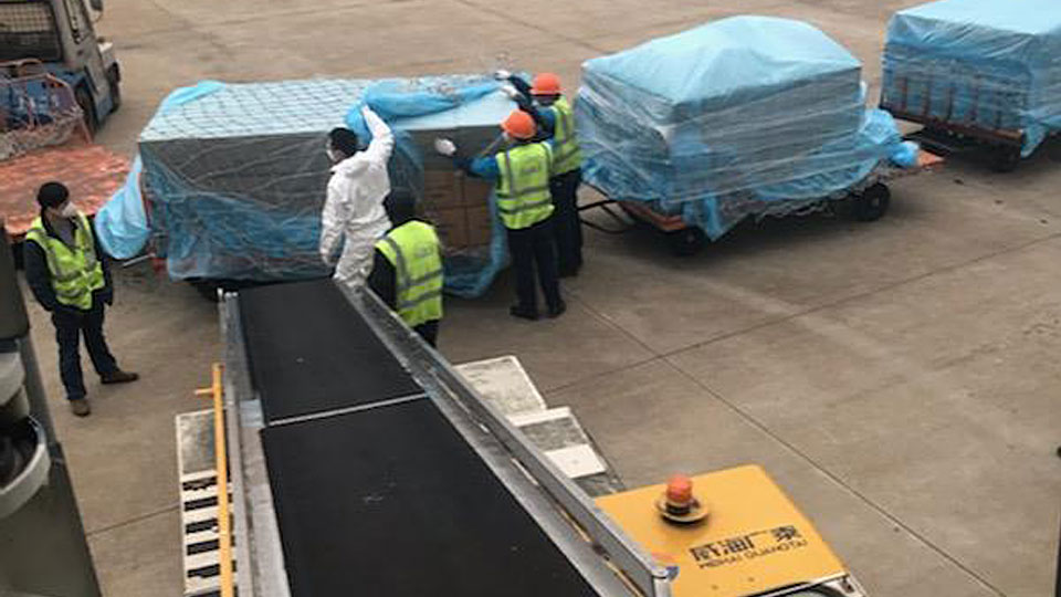 Ground crew loading cargo onto ramp