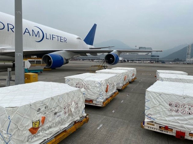Pallets of medical-grade face masks sitting beside Dreamlifter