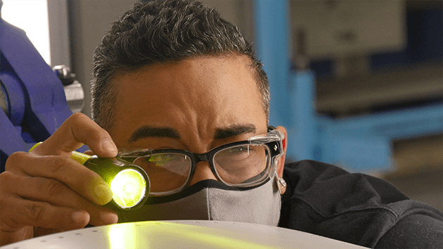   Boeing T-7A Red Hawk technician William Helton concentrates as he inspects his work on a skin panel of one of the first T-7A Red Hawk aircraft to move through the St. Louis, Missouri production line.