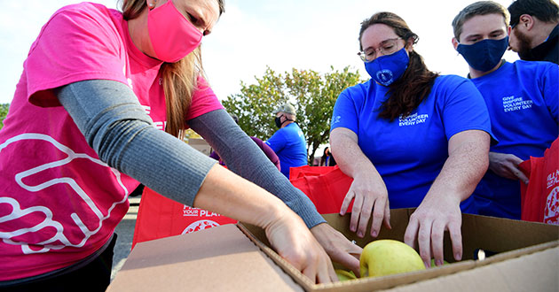 Boeing employees pack boxes with donated food
