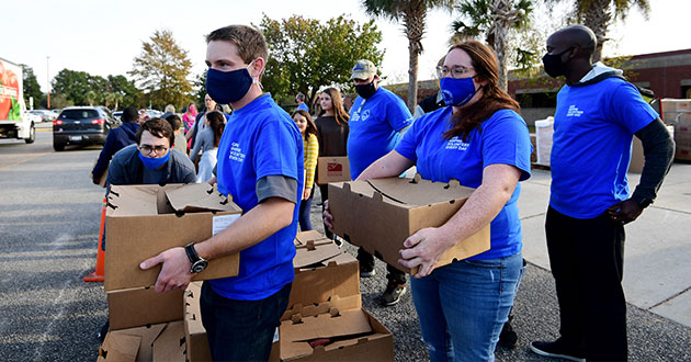 Boeing employees carrying boxes of donated food