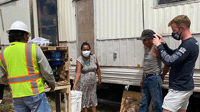 Women turning on water outside home