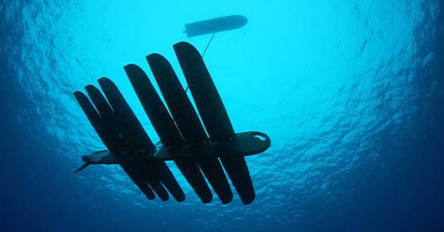   The Wave Glider, a low-profile mobile sensor platform that sits atop the ocean, uses acoustic sensors to collect and communicate data in real-time between crewed and uncrewed systems from the seabed to space. The system can stay on mission 24/7 for several months at a time.