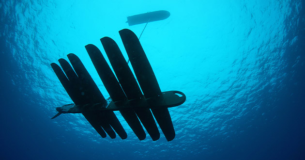 The Wave Glider, a low-profile mobile sensor platform that sits atop the ocean, uses acoustic sensors to collect and communicate data in real-time between crewed and uncrewed systems from the seabed to space. The system can stay on mission 24/7 for several months at a time.