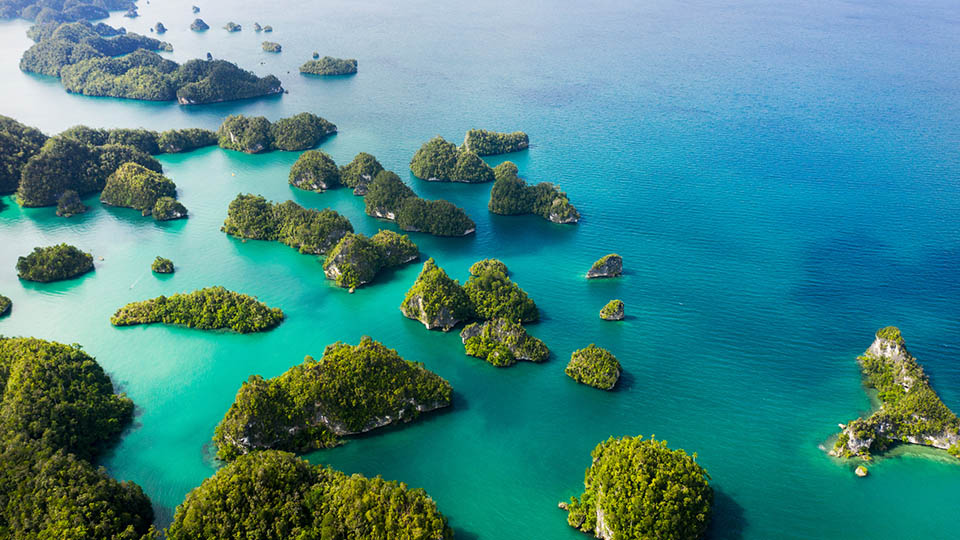 High angle shot of beautiful green islands in the vast oceans of Indonesia