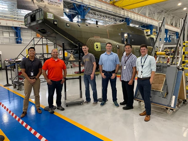   Reg Torrevillas (far left) with a new-build V-22 Osprey in 2022.