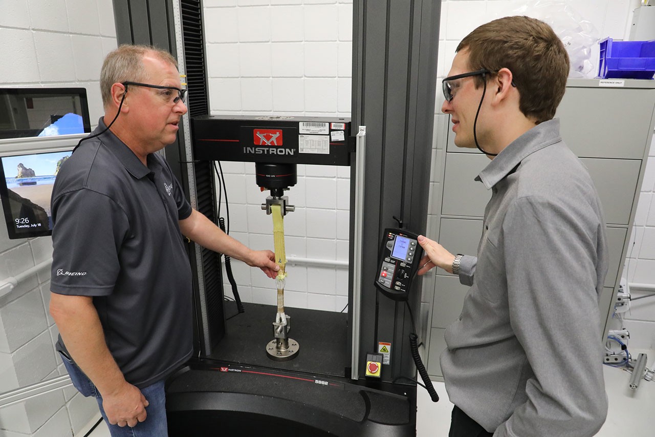 Ty Bowen demonstrates the testing of a soft link on the tensile tester machine with Kyle Kercher, Materials and Processes engineer.