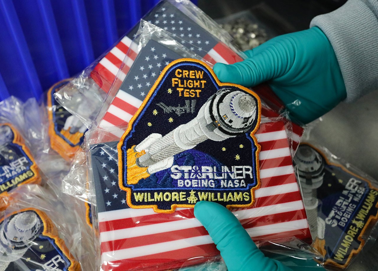 Crew Flight Test mission patches, small American flags and commemorative mission coins are part of the cargo for the Crew Flight Test.