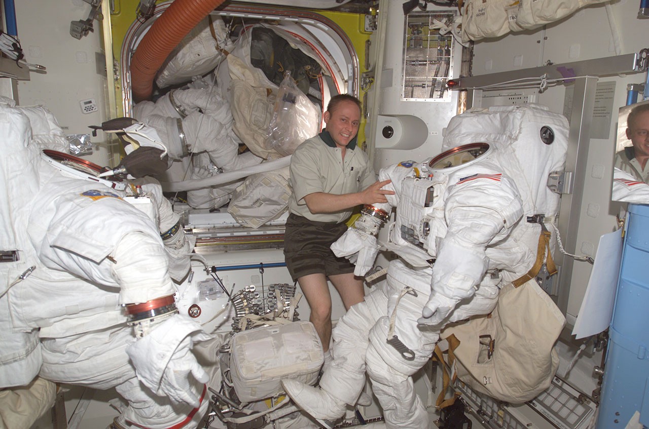 NASA astronaut Mike Fincke in 2004 as Expedition 9 NASA science officer and flight engineer, works with the Extravehicular Mobility Unit spacesuits in the Quest airlock of the International Space Station.