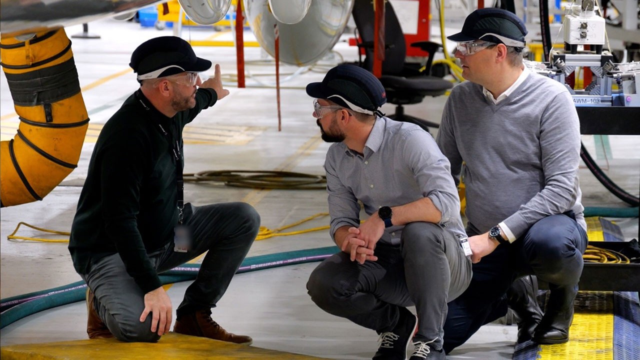 Boeing P-8 International Program Manager David Barnes (left) gives ESG business development leaders David Franz (middle) and Andreas Hauck (right) an exterior tour of a P-8A aircraft.