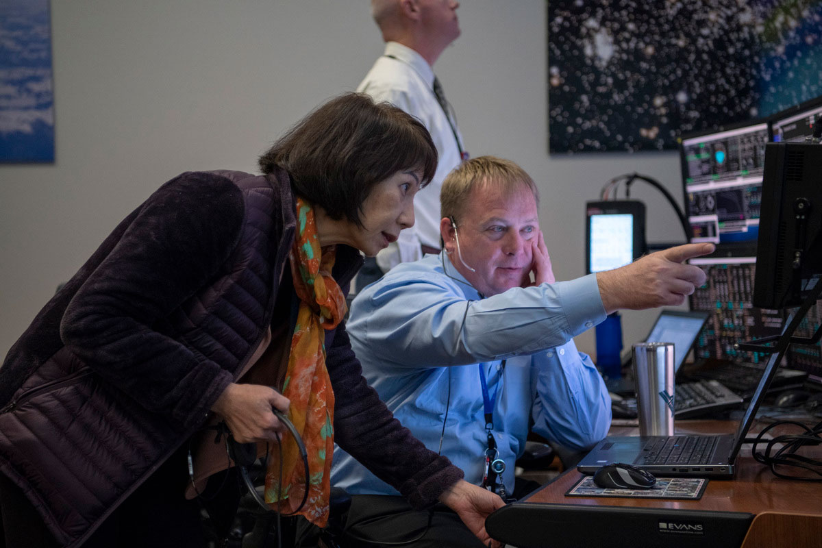 Stephanie Lu (foreground) and Aaron Kraftcheck monitor the launch of Starliner for the Orbital Flight Test in December 2019 in the Blue Flight Control Room at the Mission Control Center in Houston.