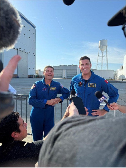 Commander Reid Wiseman, joined by Mission Specialist Jeremy Hansen stand with reporters, taking questions.