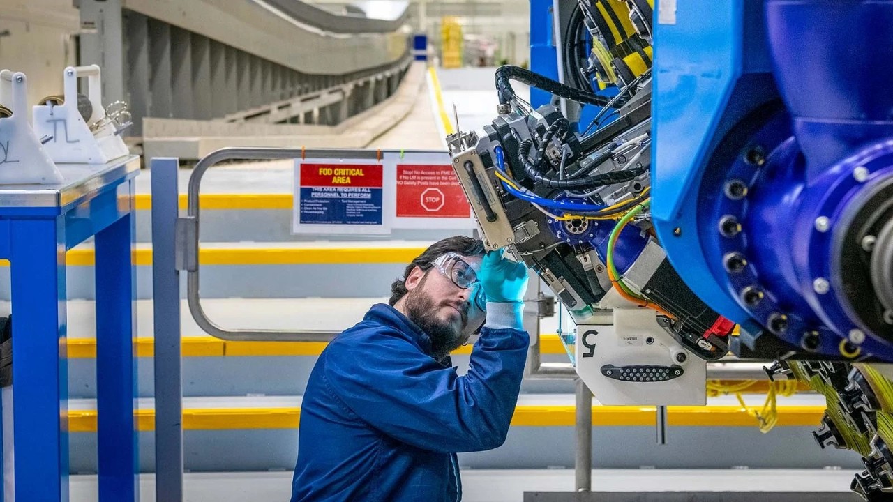 A mechanic prepares to operate the automated fiber placement machine that builds the spars for the first 777-8 Freighter’s wings. (Marian Lockhart photo)