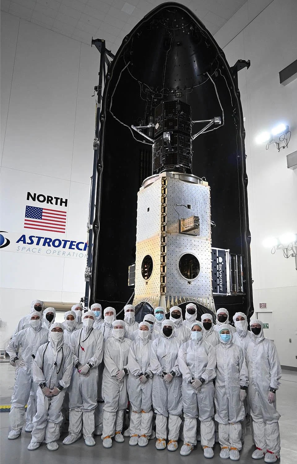 Technicians encapsulate the TRACERS within a payload fairing atop a shiny metallic stack of several other rideshare payloads at the Astrotech Space Operations facility at Vandenberg Space Force Base in California
