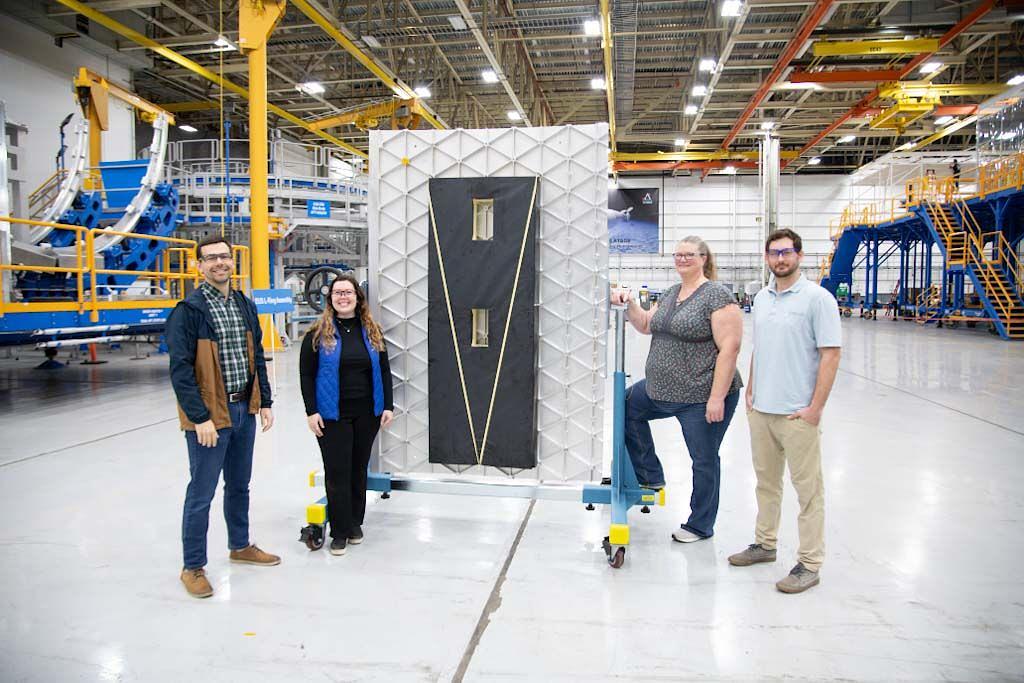 EUS Acoustic Blanket engineering teammates Sean Stockfish, Brooke Merenuk, Jessica Corbett and Ryan Riviere shown in front of the test article in the Michoud Assembly Facility EUS Gray Box Assembly area.  
