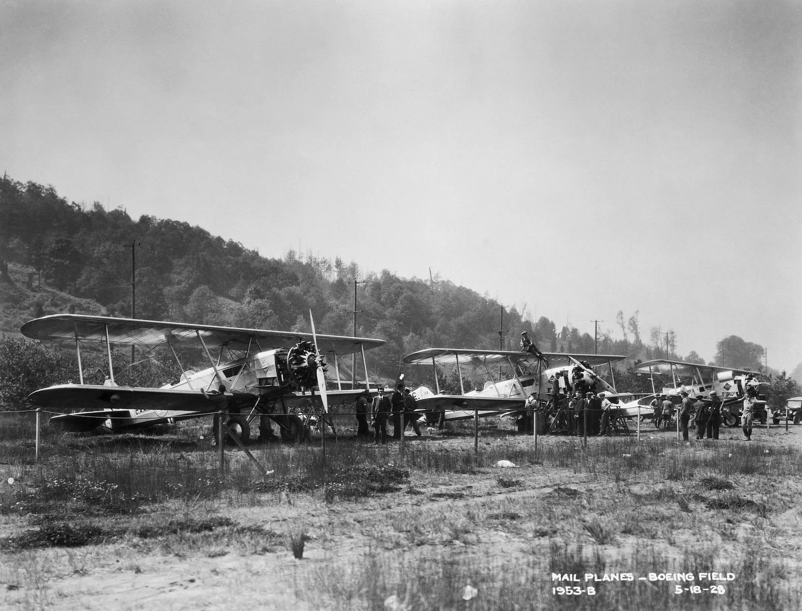 A black and white photo of three Model 40A mailplanes, biplanes, lined up on a field.