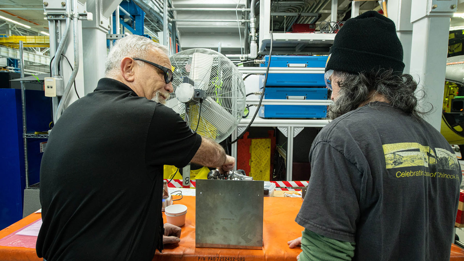 Boeing Philadelphia teammates on the Chinook production line prepare to move an Active Parallel Actuator System to the aircraft.  (© Boeing)