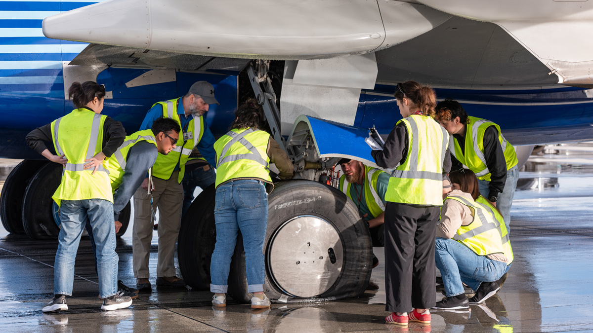 Boeing engineers and test team members examine the wheel, brakes and tires after the pressure from the tires were safely released. (Photo: Evan Wollenberg © Boeing) 