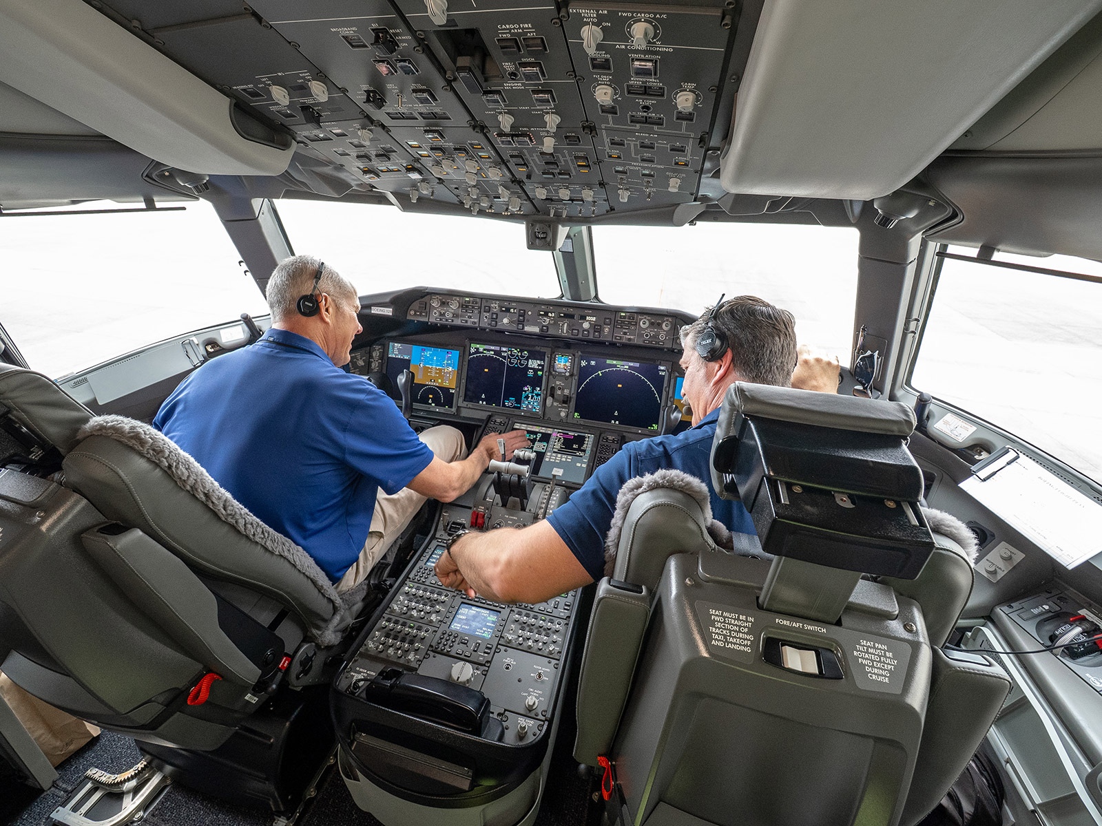 Boeing pilots are shown seated at the controls in the flight deck of the 777-9.
