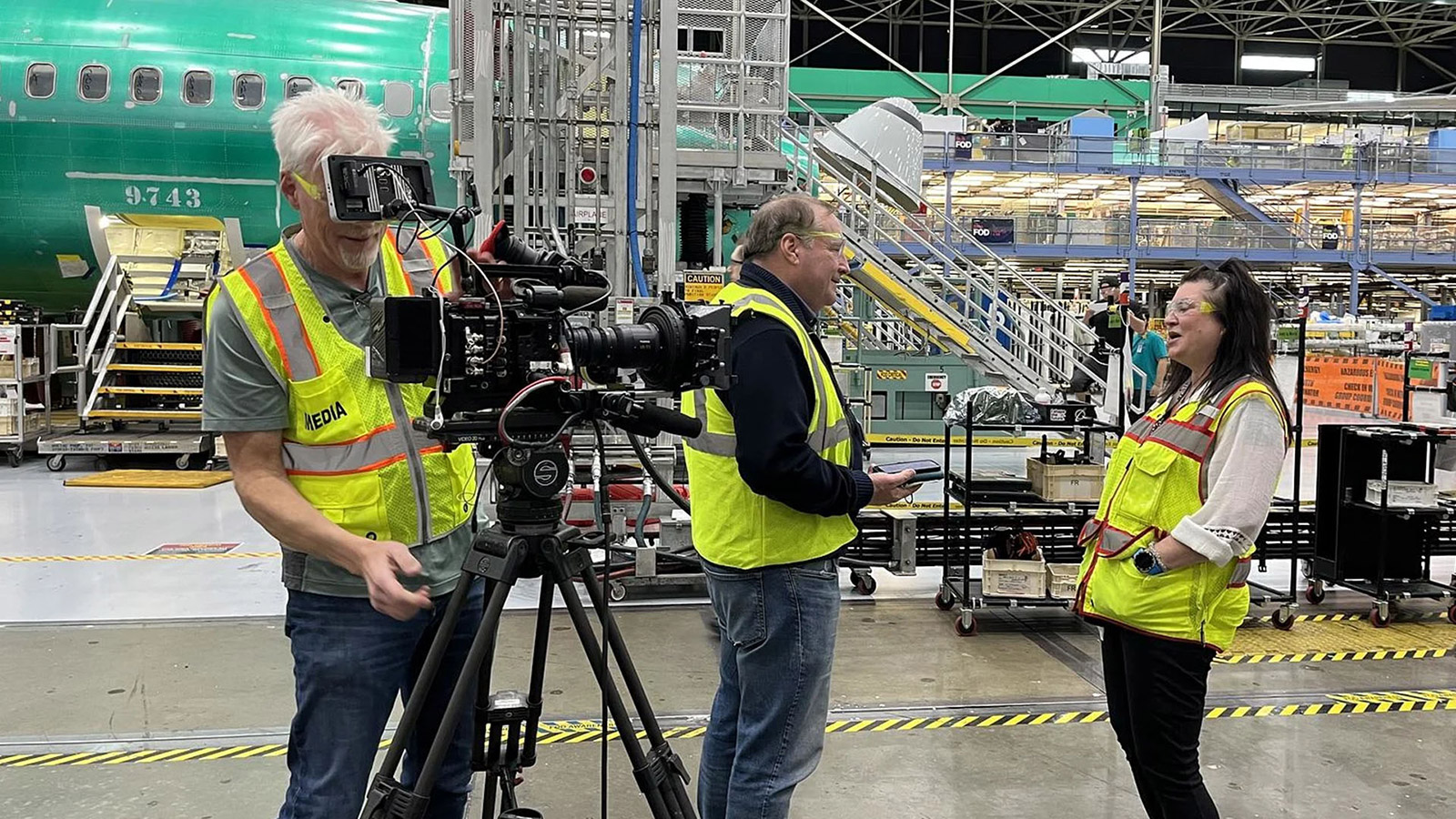 A CNBC camera crew of two interviews a Boeing line leader on the 737 factory floor