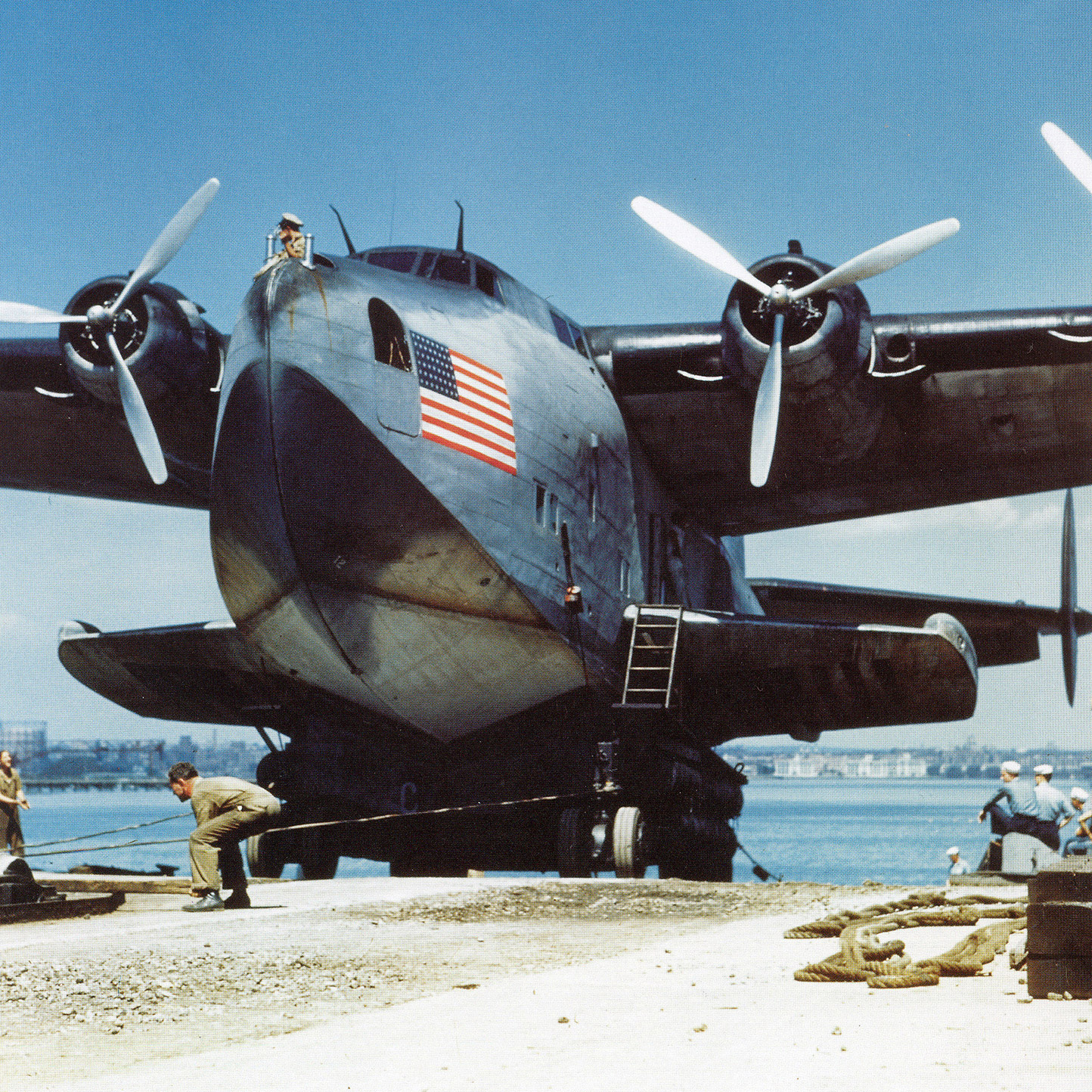 color photo of men performing maintenance on a 314 clipper aircraft
