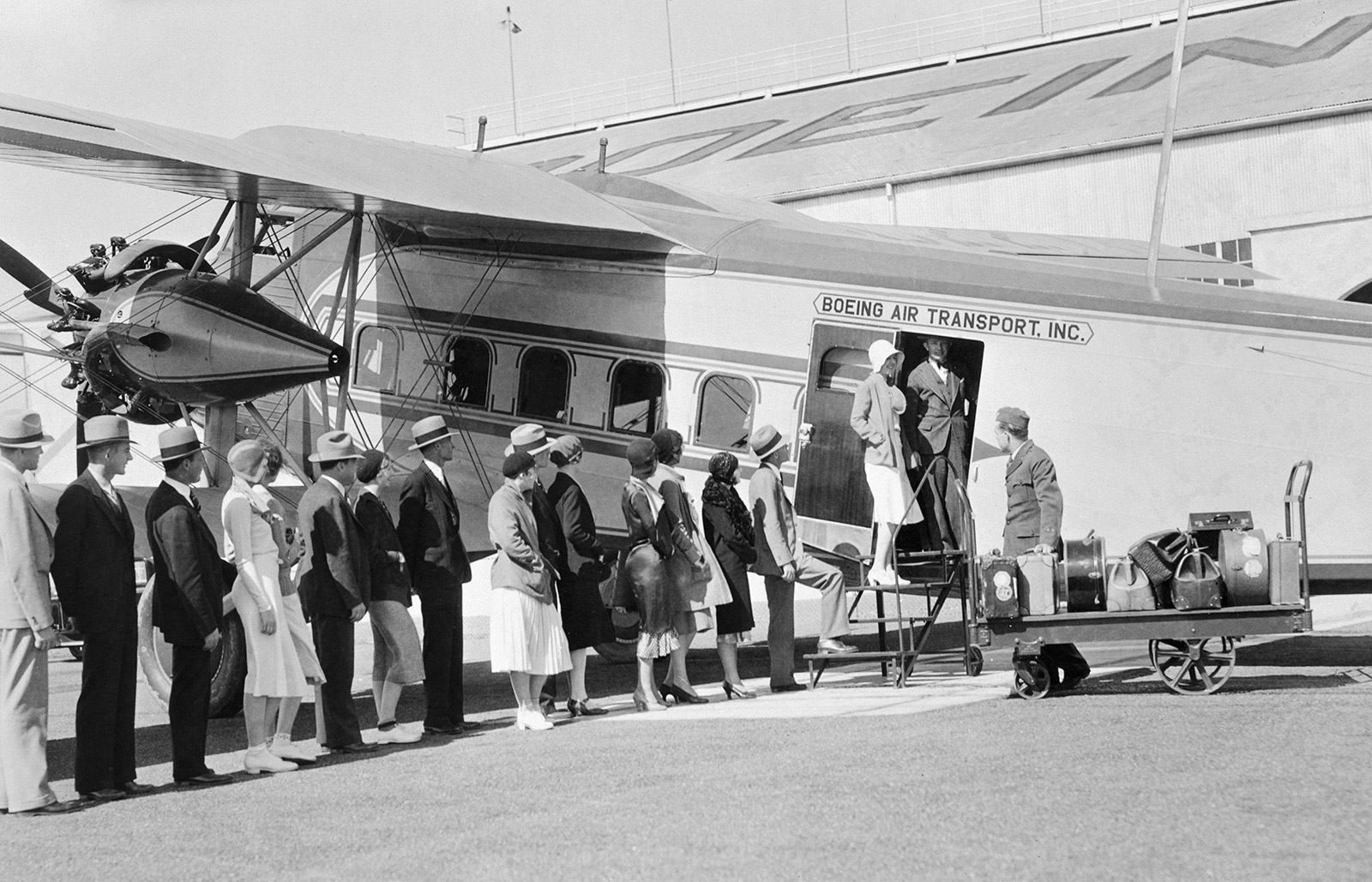 black and white photo of people lined up to board Model 80