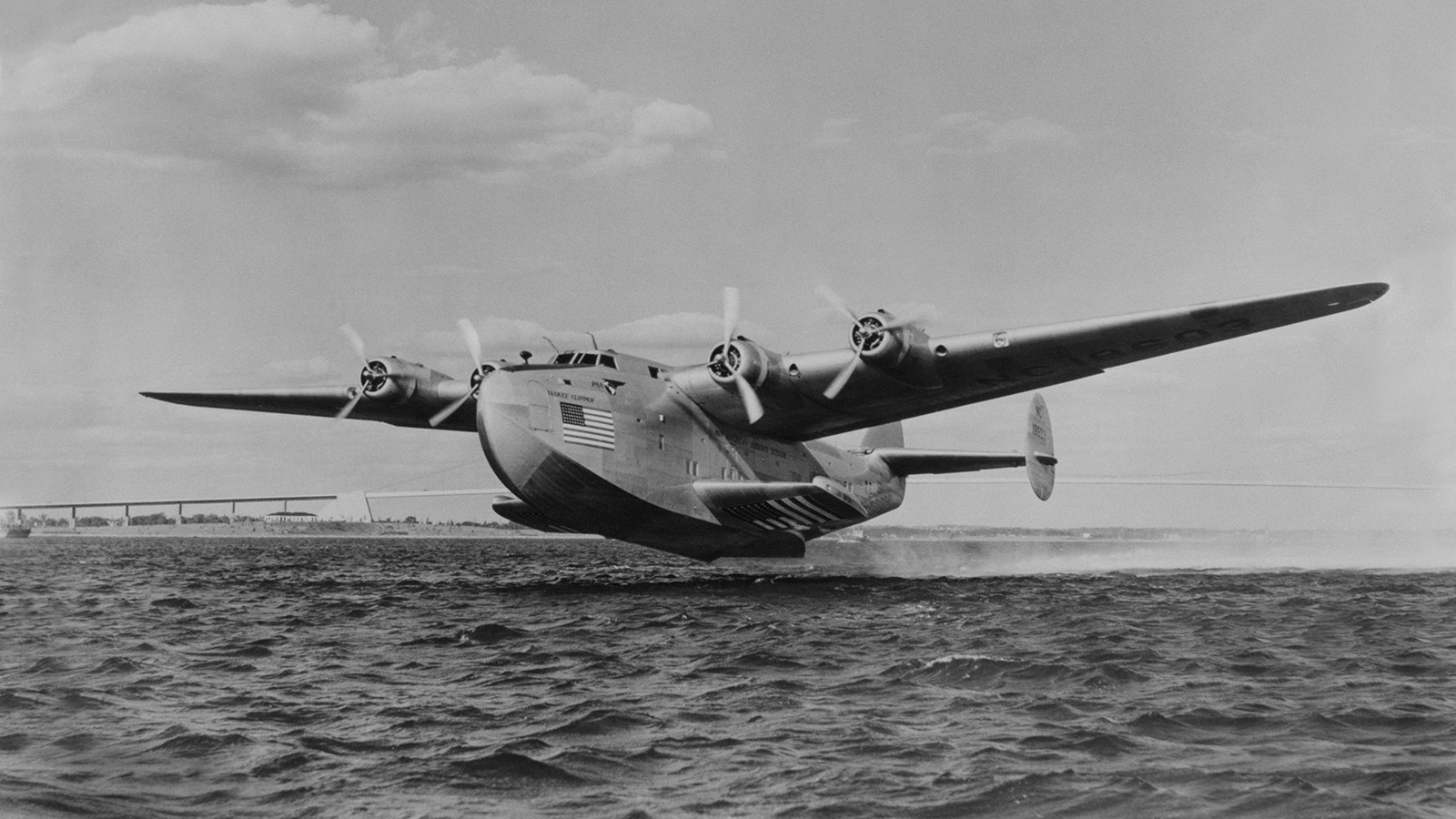 black and white photo of Clipper taking off over water