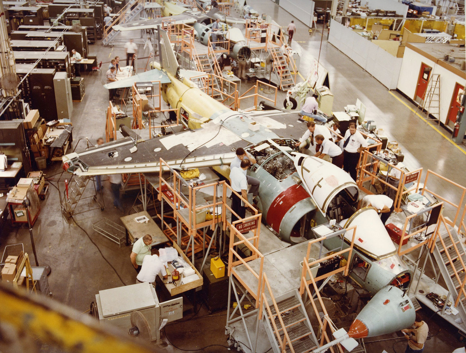 color photo of people working on aircraft in factory
