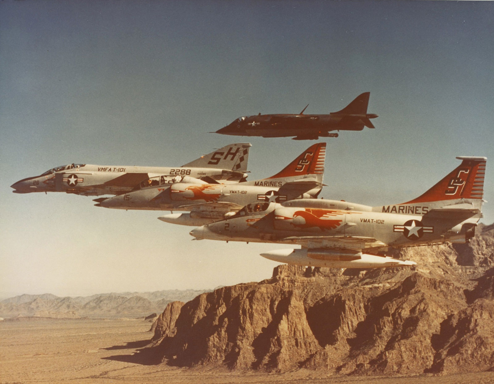 color photo of jets flying by mountains