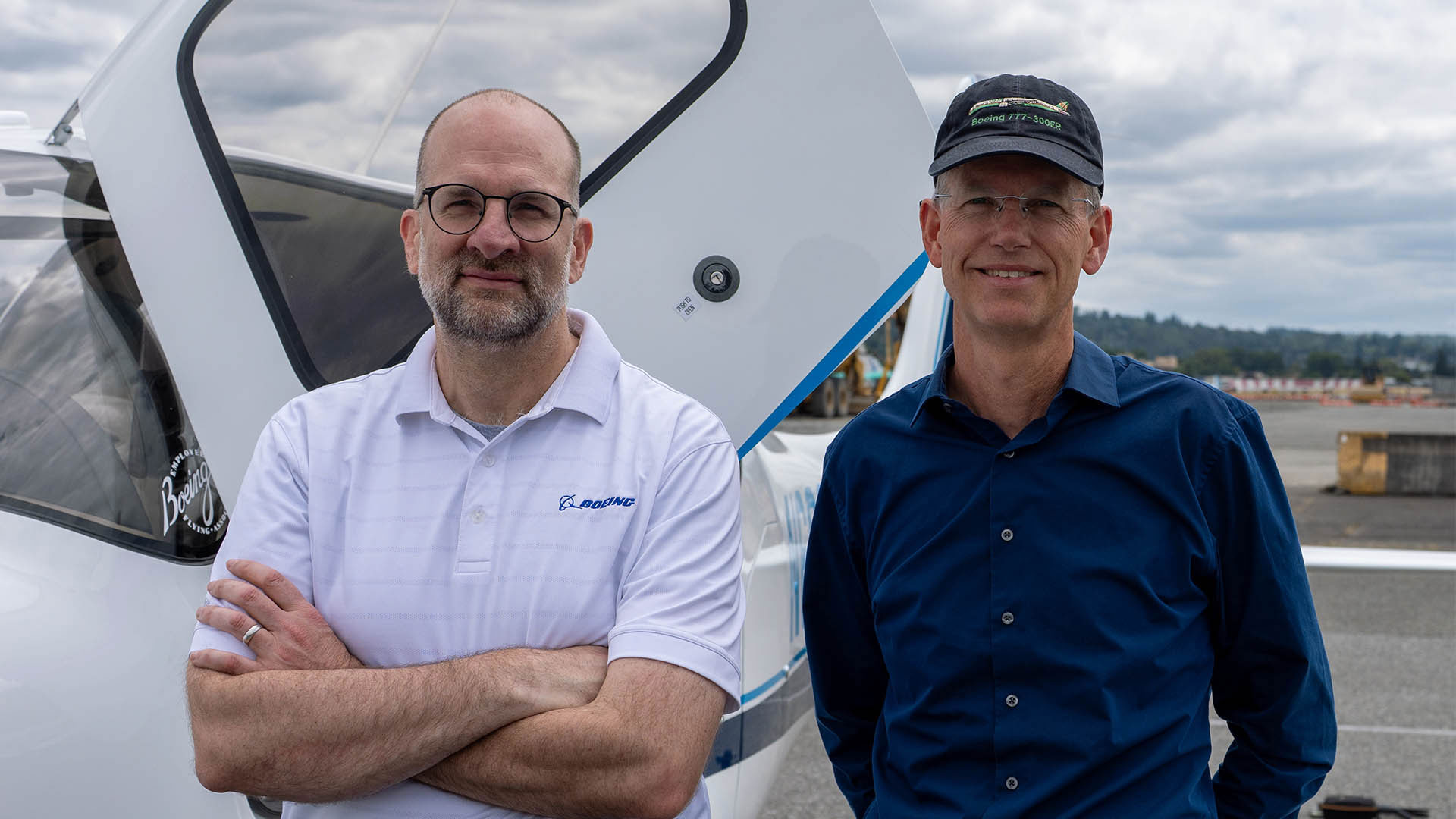 Boeing Employees' Flying Association members Tom Sanderson, left, and Jim Dobberfuhl, right, pose in front of the group’s special-edition Cirrus airplane.